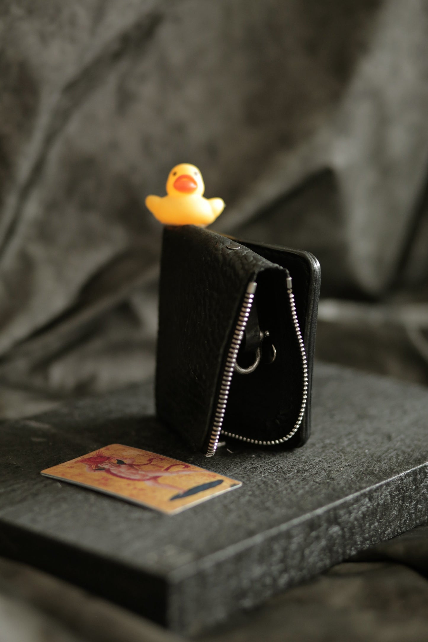 Boddin #007 black veg tan reverse horse culatta leather snap wallet with zipper pouch and card slot on dark fabric background.