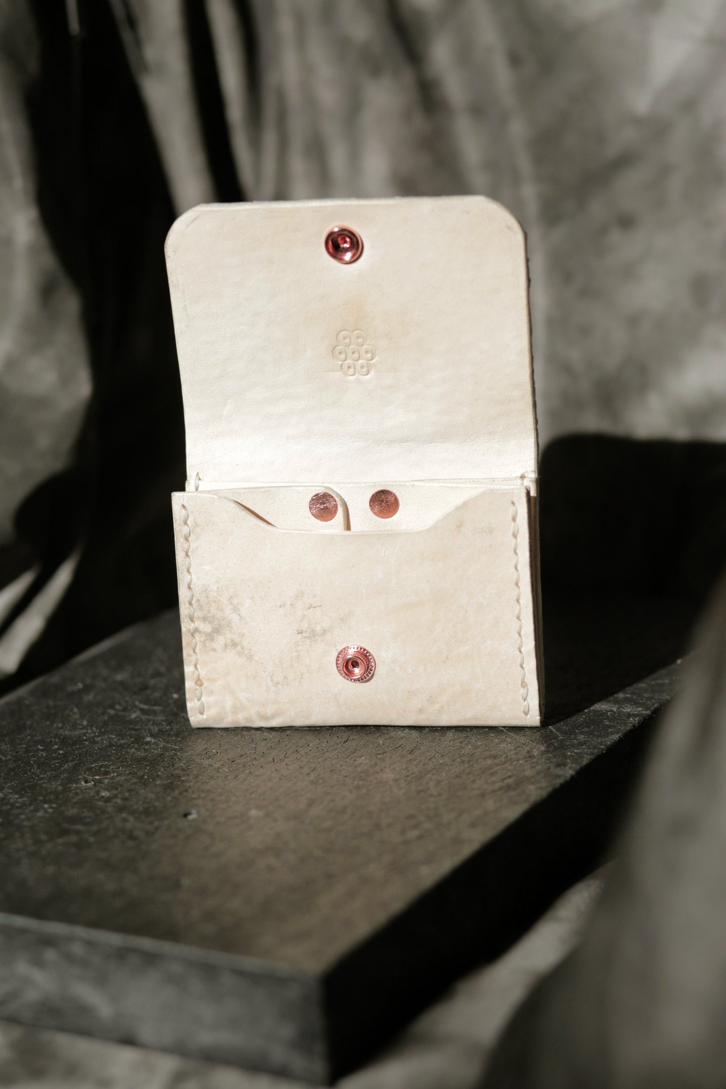 Hermann minimal snap wallet in dirty white reverse horse culatta leather with copper snap and rivets, open view.