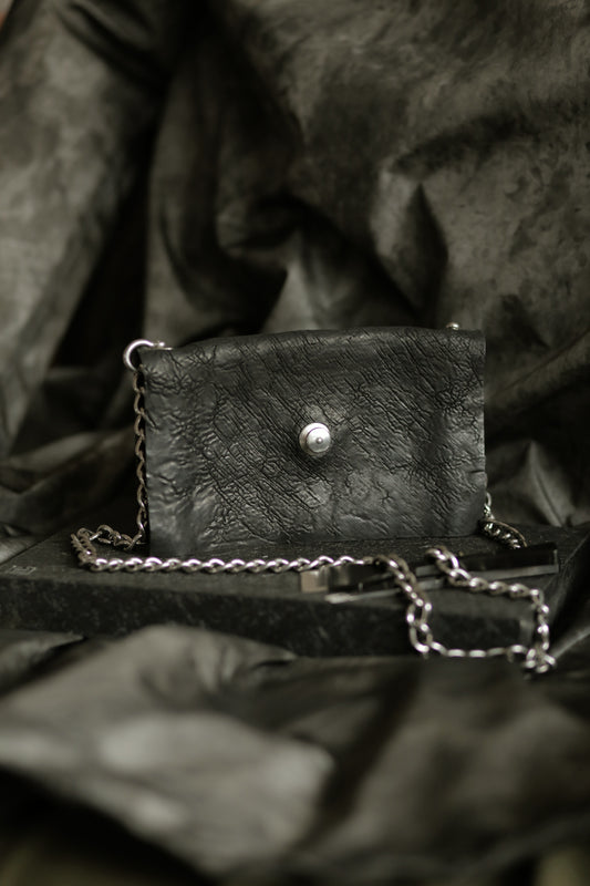 Köpenicker #004 black hand-stitched leather bag with polished steel chain strap and secure loxx lock closure.