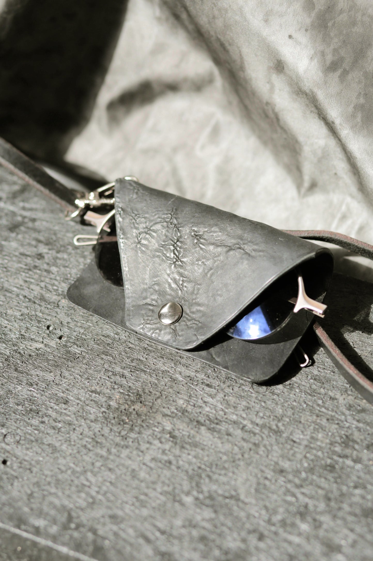 Leather case with sunglasses on a textured surface