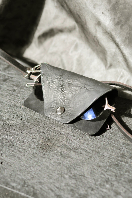 Leather case with sunglasses on a textured surface