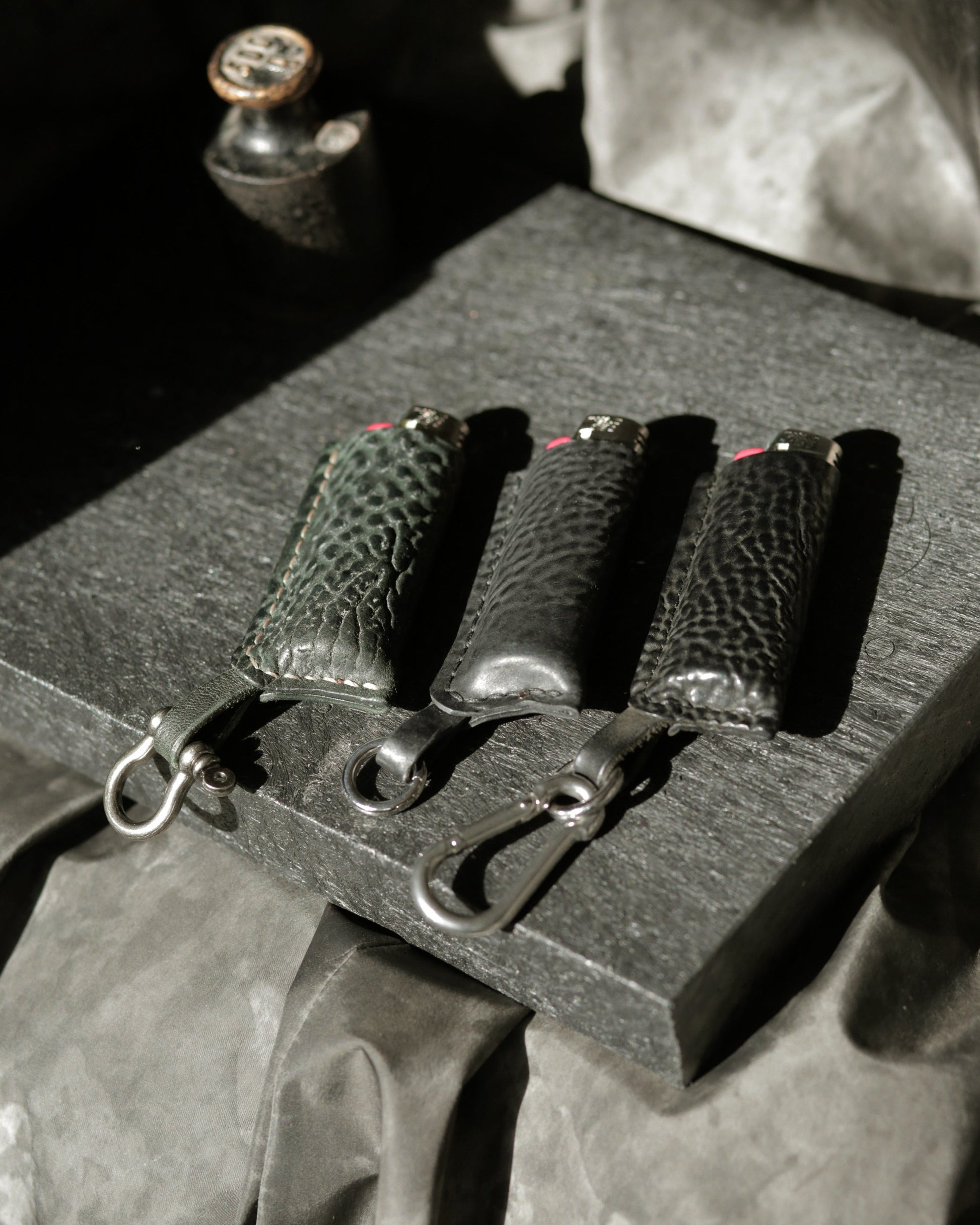 Three lighters with horse culatta cases in dark green, black polished, and black new finishes.