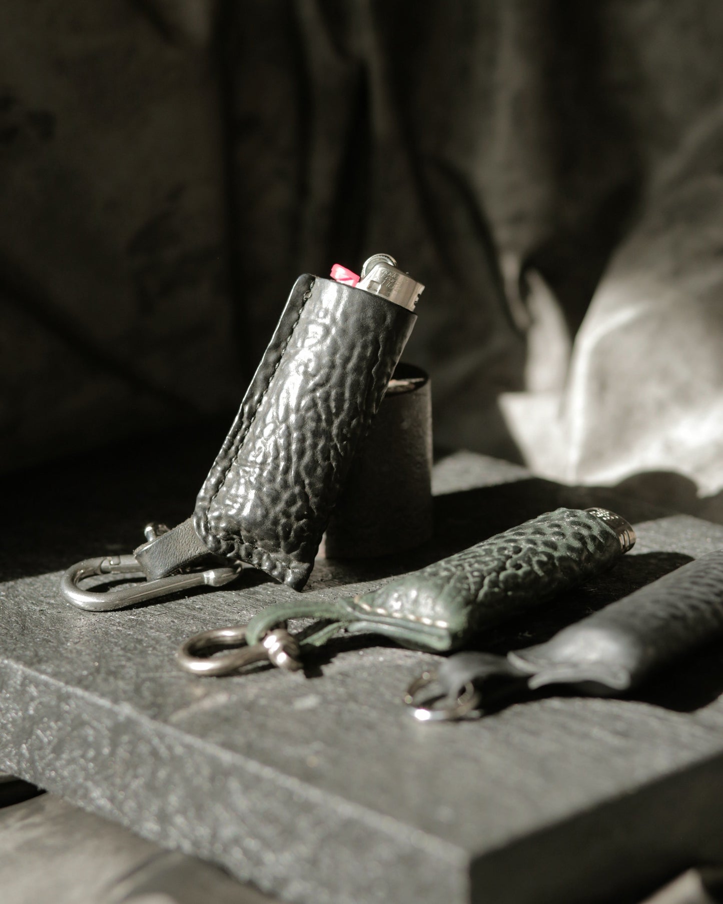 Lighter with a horse culatta leather case in dark green and black with metal hardware options.