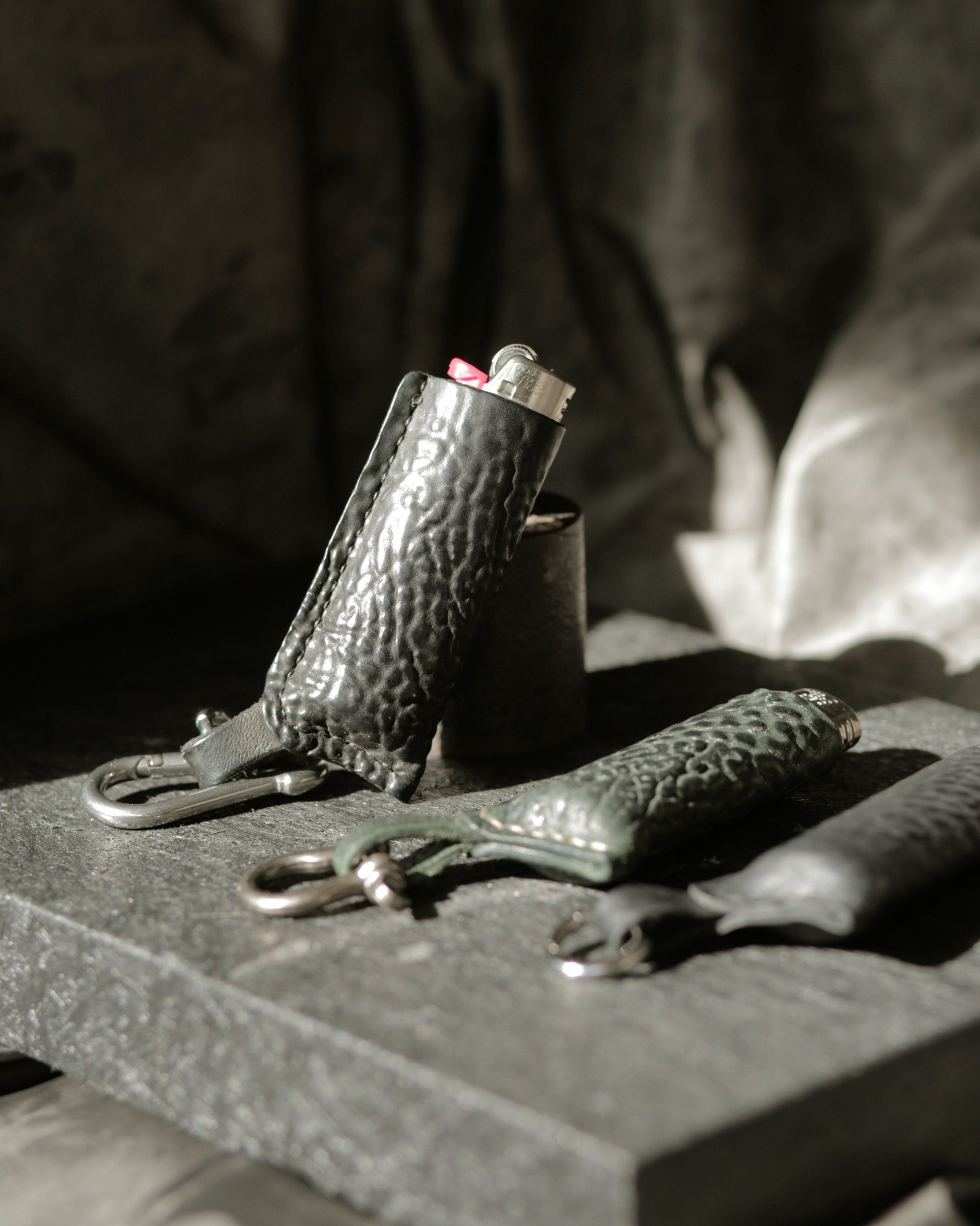 Lighter with a horse culatta leather case in dark green and black with metal hardware options.