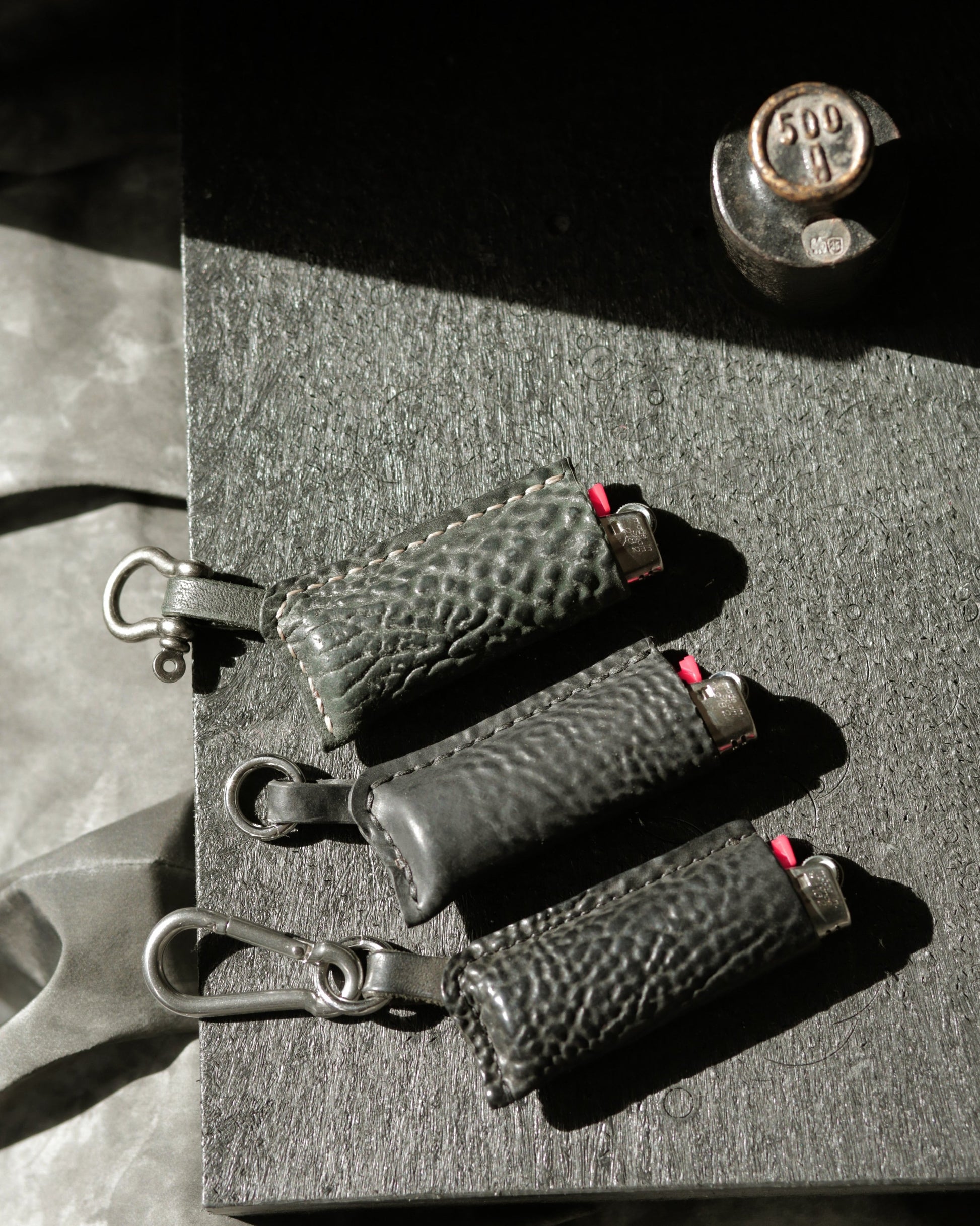 Lighter with horse culatta case in dark green and two black variants with different hardware options.